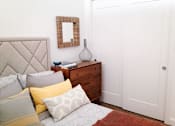 Thumbnail 21 of 36 - Bedroom with upholstered headboard and wooden dresser at 68 Beale Apartments, Quincy, 02169